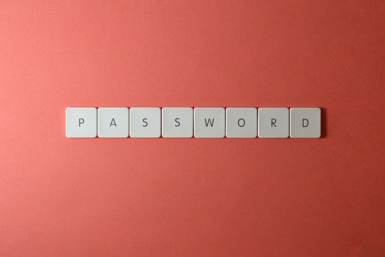 White keyboard-style letter tiles spelling PASSWORD on a coral background
